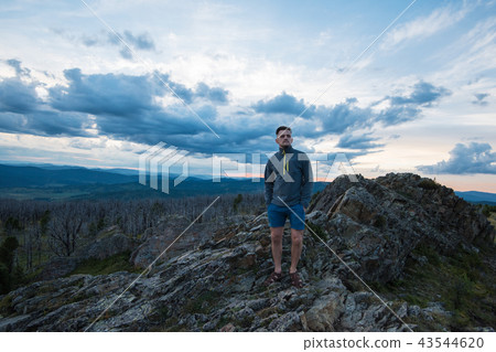 Man standing on top of cliff Man standing on top of cliff 43544620