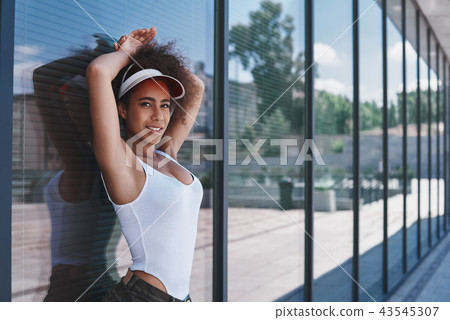 Young woman in visor free style on the street leaning on window Young woman in visor free style on the street leaning on window 43545307