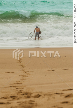 a fisherman fishing Sand crab on Mai Khao beach. a fisherman fishing Sand crab on Mai Khao beach. 43546254