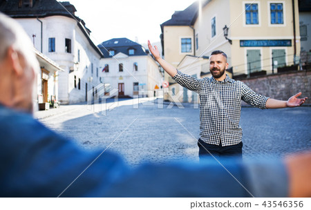 An adult hipster son and his senior father in town, greeting. 43546356