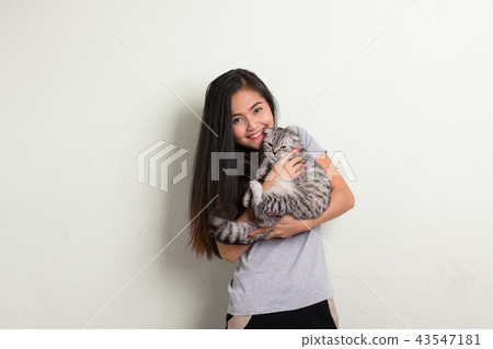 Young happy beautiful Asian woman smiling while holding cute cat Young happy beautiful Asian woman smiling while holding cute cat 43547181