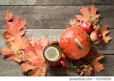 Cup of tea, autumn leaves and pumpkins on board. Cup of tea, autumn leaves and pumpkins on board. 43548036
