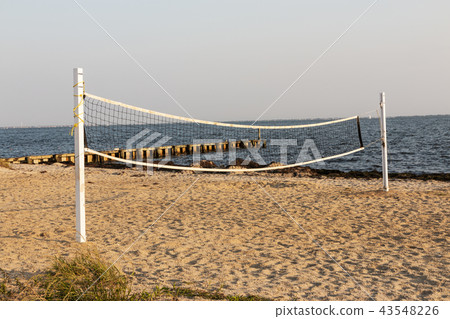 Beach volleyball net with water jetty background Beach volleyball net with water jetty background 43548226