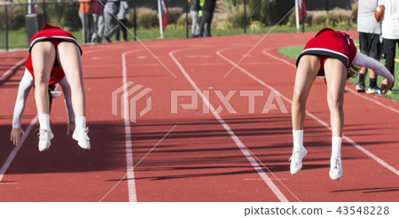 Two cheerleaders flipping Two cheerleaders flipping 43548228