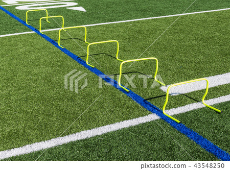 Six yellow mini hurdles set up on field 43548250