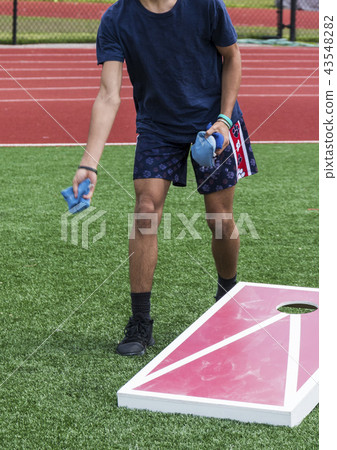 Plying corn hole outdoors 43548282