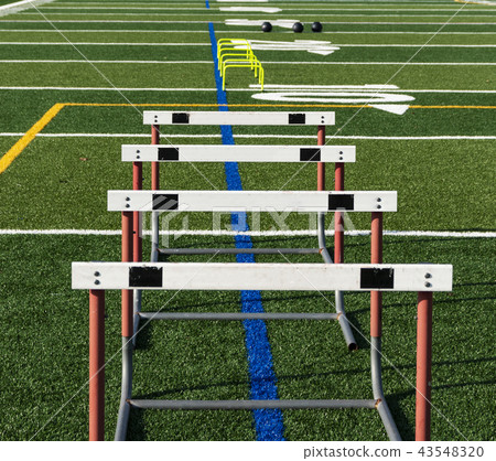 Hurdles and med balls on turf for practice 43548320