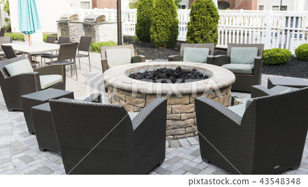 Fire pit set up behind hotel with barbeque grills 43548348