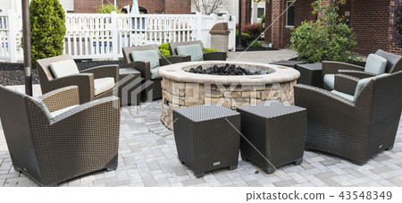 Fire pit surrounded by chairs on a patio 43548349