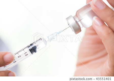 Female doctor holding syringe vaccine Female doctor holding syringe vaccine 43551401