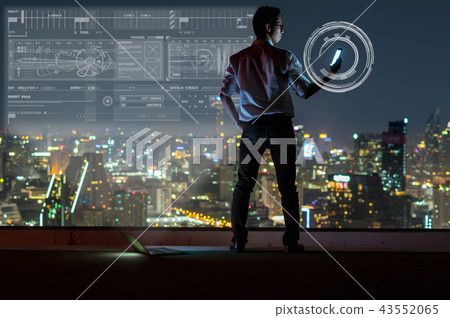 Asian businessman standing and using the smart mobile phone showing digital virtual screen over the cityscape background at night time, Business success and technology concept Asian businessman standing and using the smart mobile phone showing digital virtual screen over the cityscape background at night time, Business success and technology concept 43552065