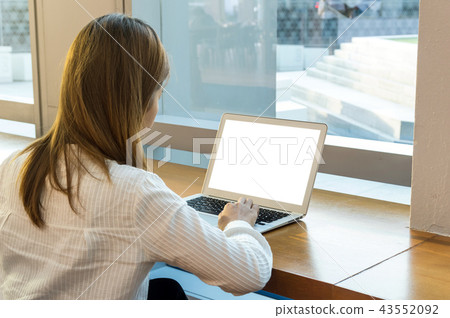 Back side of Businesswoman in casual suit sitting and using computer laptop beside the windows glass in modern office, Business technology concept Back side of Businesswoman in casual suit sitting and using computer laptop beside the windows glass in modern office, Business technology concept 43552092