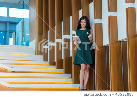 Asian Businesswomen using the tablet with cheerful action on the staircase In the modern creative Office, business success concept Asian Businesswomen using the tablet with cheerful action on the staircase In the modern creative Office, business success concept 43552093