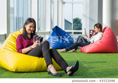 Two Asian Women using social network each technology equipment In the modern creative Office, business social network concept Two Asian Women using social network each technology equipment In the modern creative Office, business social network concept 43552096