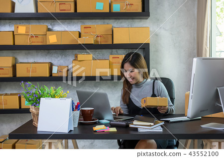 Young asian teenager owner business woman work at home for online shopping, checking order and prepaing package the product with office equipment, entrepreneur and alpha generation life style concept 43552100