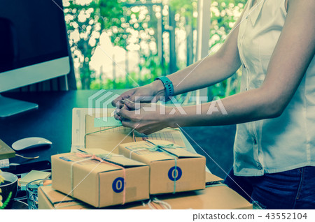 Closeup hand Young asian teenager owner business woman tying a rope prepaing package the product with office equipment online shopping, entrepreneur and alpha generation life style concept Closeup hand Young asian teenager owner business woman tying a rope prepaing package the product with office equipment online shopping, entrepreneur and alpha generation life style concept 43552104