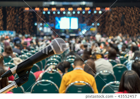 Microphone over the Abstract blurred photo of conference hall or seminar room in Exhibition Center background with Speakers on the stage and attendee background, Business meeting and education concept Microphone over the Abstract blurred photo of conference hall or seminar room in Exhibition Center background with Speakers on the stage and attendee background, Business meeting and education concept 43552457
