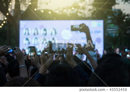 Fan club people taking photographs by smart phone during music entertainment public concert outdoor in evening time, Musical and concert concept Fan club people taking photographs by smart phone during music entertainment public concert outdoor in evening time, Musical and concert concept 43552458