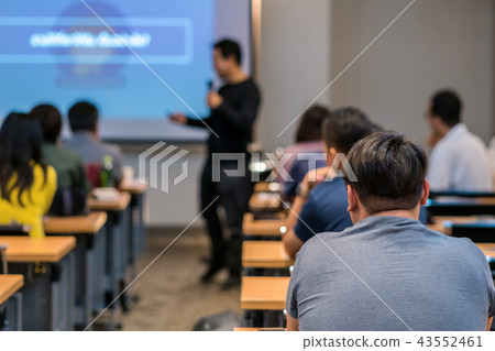 Rear side of Audiences sitting and listening the speackers on the stage in low light meeting room, event and seminar concept Rear side of Audiences sitting and listening the speackers on the stage in low light meeting room, event and seminar concept 43552461