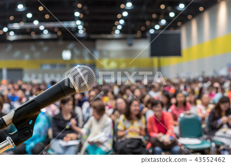 Microphone over the Abstract blurred photo of conference hall or seminar room in Exhibition Center background with Speakers on the stage and attendee background, Business meeting and education concept Microphone over the Abstract blurred photo of conference hall or seminar room in Exhibition Center background with Speakers on the stage and attendee background, Business meeting and education concept 43552462