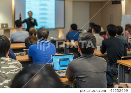 Rear side of Audiences sitting and listening the speackers on the stage in low light meeting room, event and seminar concept Rear side of Audiences sitting and listening the speackers on the stage in low light meeting room, event and seminar concept 43552469