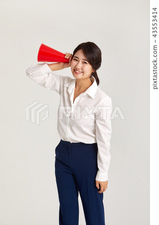 A twenties business woman communicating with the world. A loudspeaker, a sound, a funnel 43553414