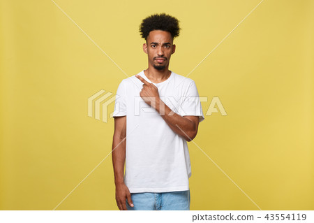serious dark-skinned African American young man shows a finger upwards serious dark-skinned African American young man shows a finger upwards 43554119