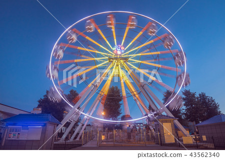 Ferris wheel in motion against the blue sky Ferris wheel in motion against the blue sky 43562340