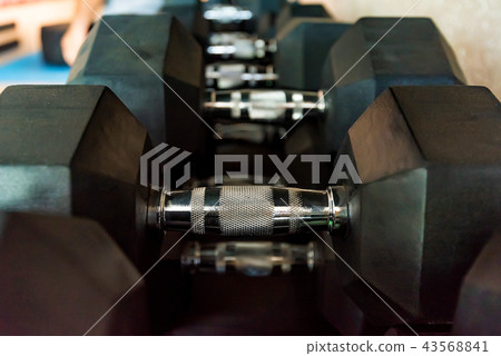 Closeup image of big black chrome dumbbells Closeup image of big black chrome dumbbells 43568841