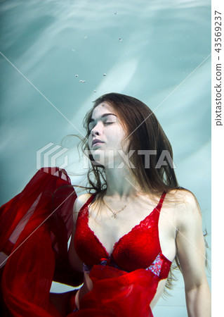 Woman under the water in a red dress. 43569237