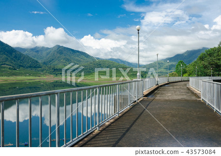 Pathway on the dam for looking mountain and lake Pathway on the dam for looking mountain and lake 43573084