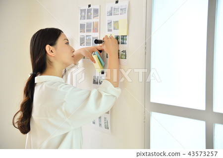 Creative woman writing notes on the wall Creative woman writing notes on the wall 43573257
