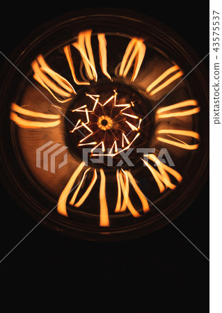 Large tungsten lamp glowing over dark Large tungsten lamp glowing over dark 43575537