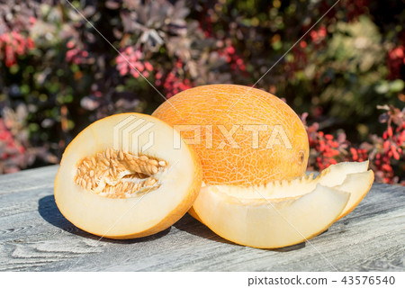 Whole and sliced melon on wooden table outdoors Whole and sliced melon on wooden table outdoors 43576540