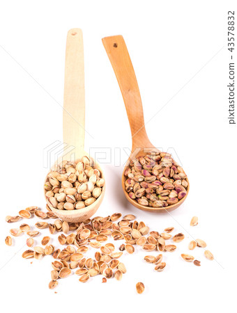 Close-up of couple spoons with peeled and unpeeled pistachios. 43578832