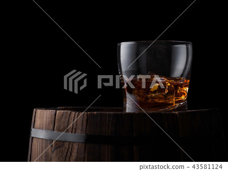 Glass of whiskey with ice cubes on top Glass of whiskey with ice cubes on top 43581124