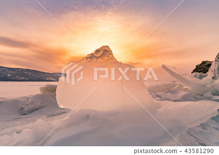 Sunset behind breaking ice over freeze water lake 43581290