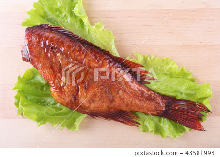 Smoked fish and lemon on green lettuce. Smoked fish and lemon on green lettuce. 43581993