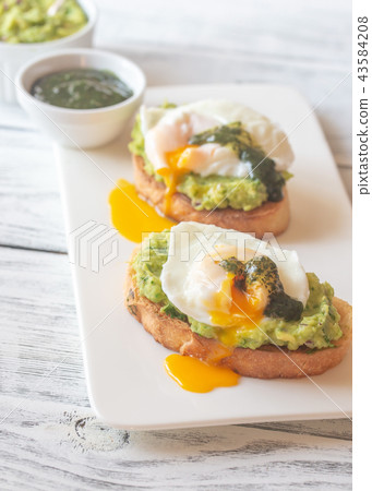Sandwiches with guacamole and poached eggs Sandwiches with guacamole and poached eggs 43584208