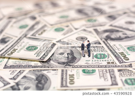 Miniature people and money. Creative concept of a deal. Businessmen shake hands. Miniature people and money. Creative concept of a deal. Businessmen shake hands. 43590928