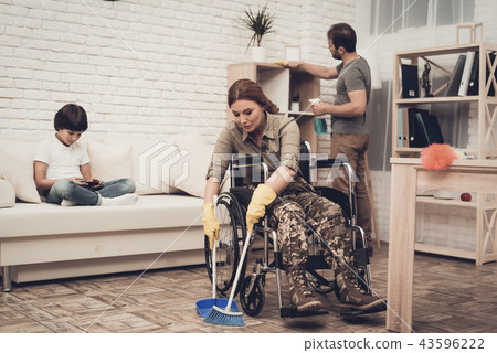 Female Veteran In A Wheelchair Is Cleaning House. Female Veteran In A Wheelchair Is Cleaning House. 43596222