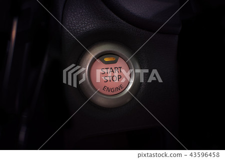 Engine start button of car with a orange light. 43596458