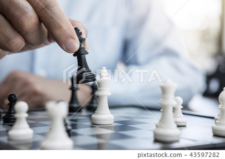 Businessman's hand playing chess game to development analysis ne Businessman's hand playing chess game to development analysis ne 43597282