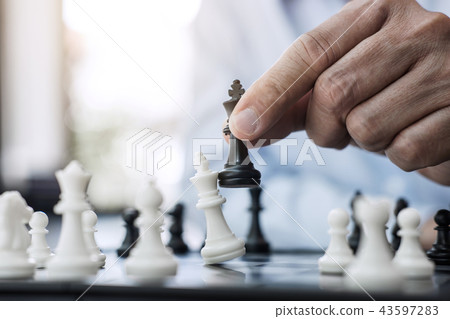 Businessman's hand playing chess game to development analysis ne Businessman's hand playing chess game to development analysis ne 43597283