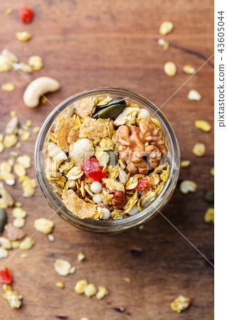 Granola, muesli in glass jar. Healthy breakfast. Organic oats with nuts, berries. Top view. 43605044