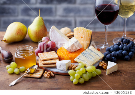 Assortment of cheese, grapes with red wine in glasses. Stone and wood background. 43605188