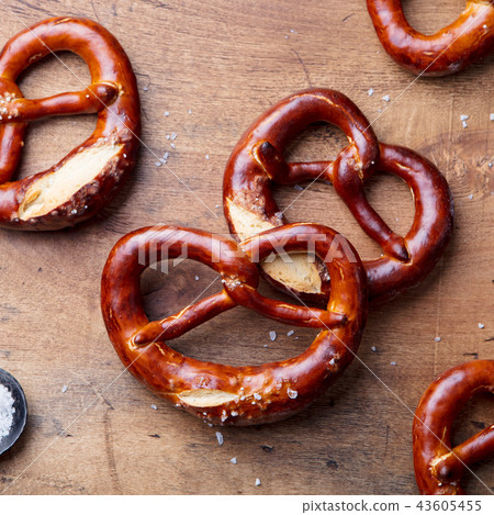 Freshly baked salted pretzel on wooden background. Beer snack. Top view. 43605455