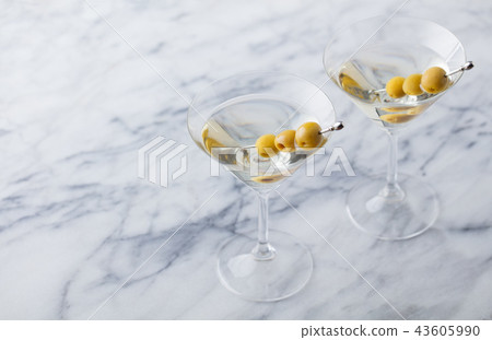 Martini cocktail with green olives on marble table background. Copy space. 43605990