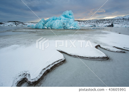 Famous Fjallsarlon glacier and lagoon with icebergs swimming on frozen water. 43605991