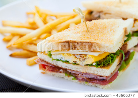 Club sandwich with french fries on a white plate. Close up. Club sandwich with french fries on a white plate. Close up. 43606377
